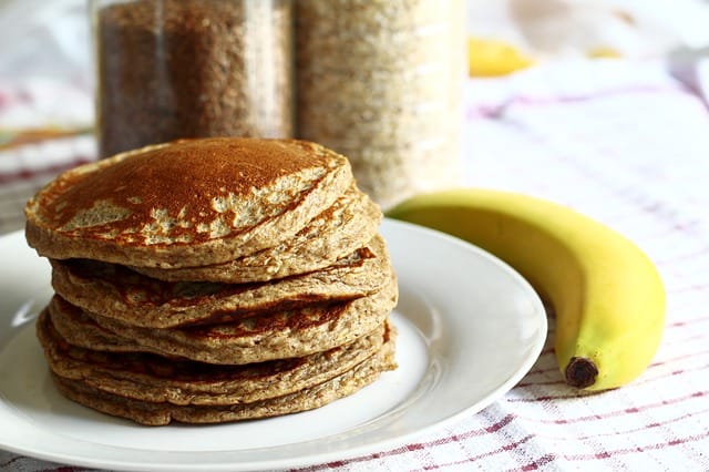 whole wheat pancakes with a banana on a table.