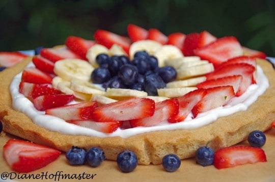 summer fruit tart made with sugar cookie crust, berries, and bananas