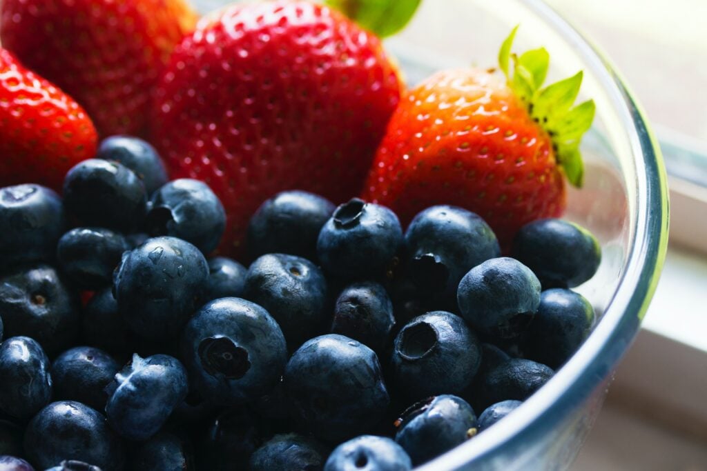 blueberries and strawberries in a glass bowl