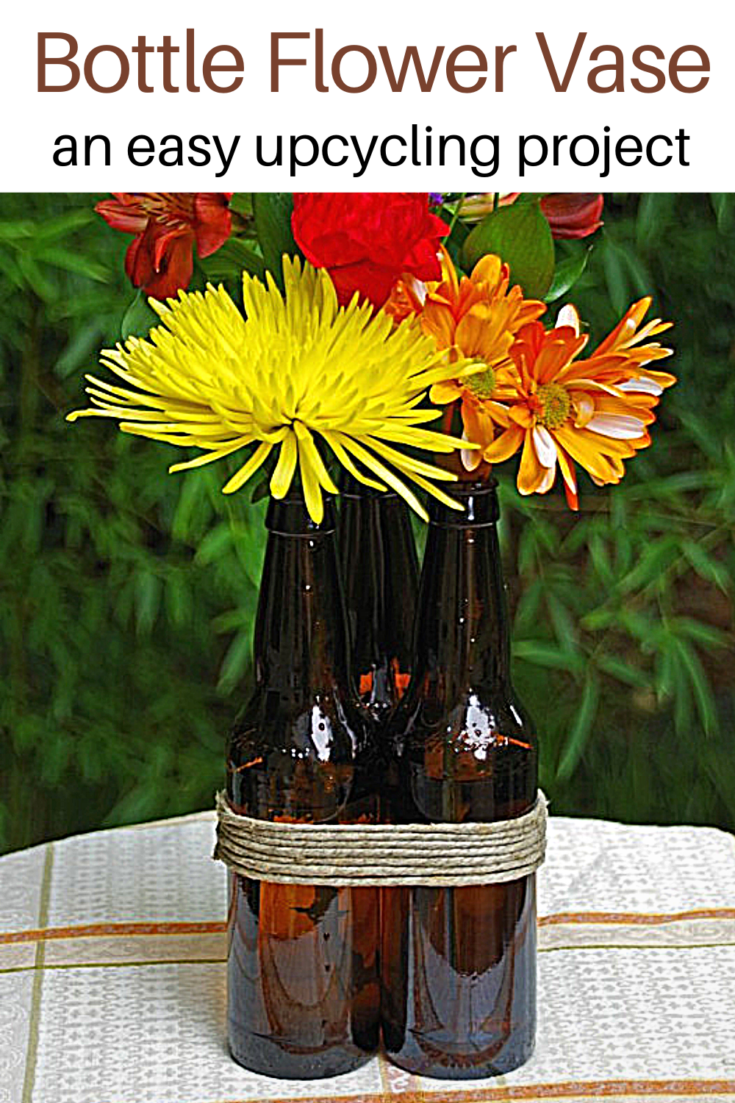 flowers in a beer bottle with text overlay 'Bottle Flower Vase easy upcycling project'