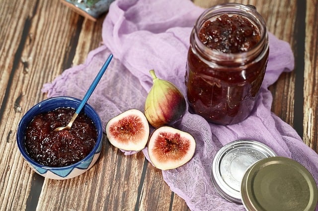 Fig jam in a bowl with fresh figs next to it.