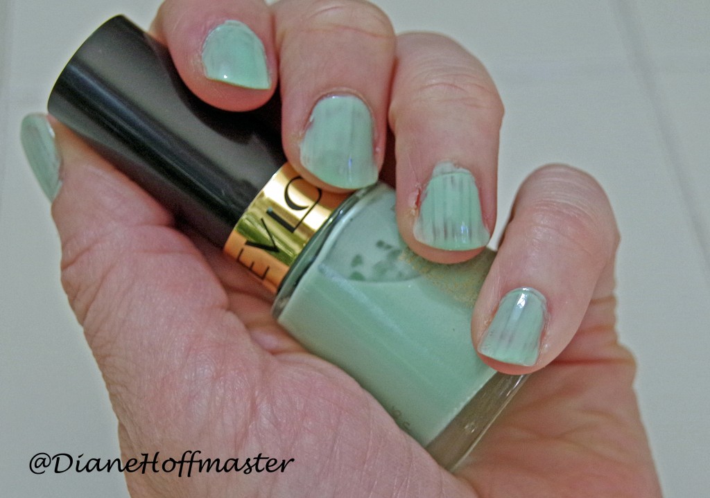 mint green nail polish being held in hand