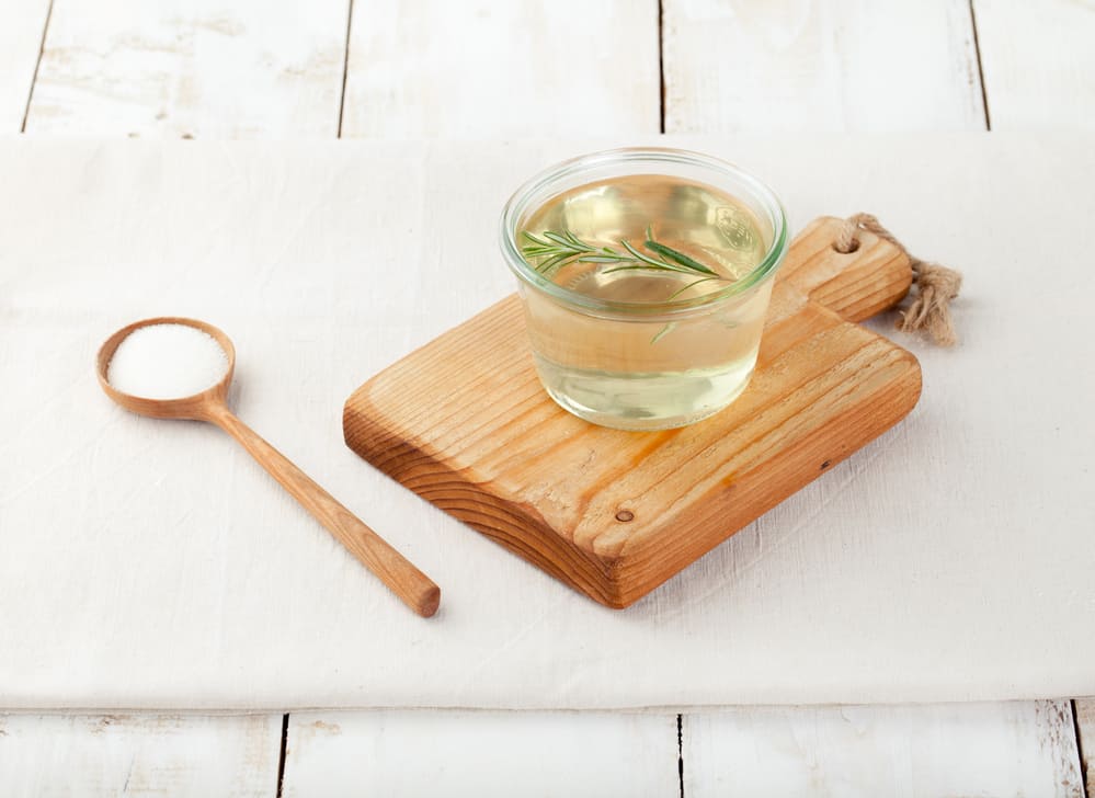 Sugar syrup in a glass bowl on a white wooden background