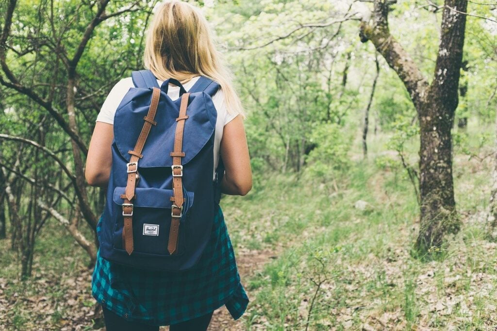 young woman hiking with a backpack on