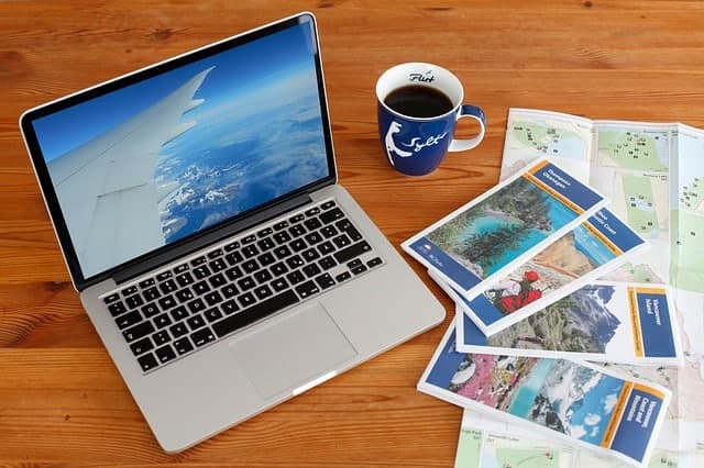 maps and computer on table with cup of coffee