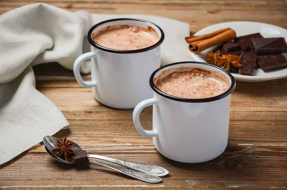 homemade hot chocolate and spices on a wooden table