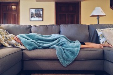 teenager sleeping on couch with blanket