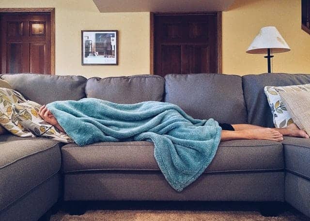 teenager sleeping on couch with blanket