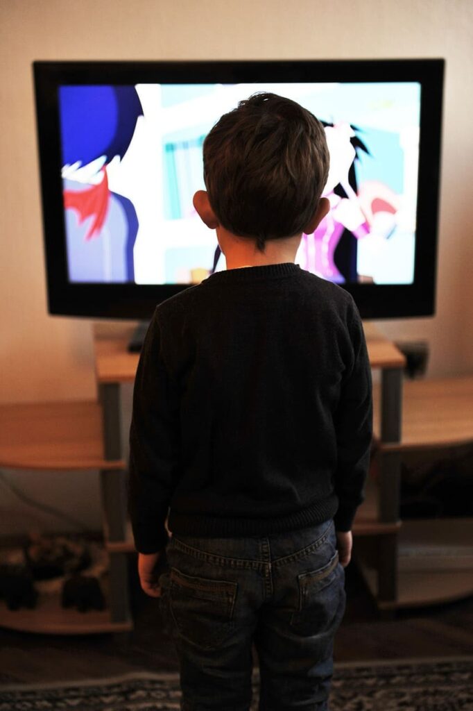 child sitting in front of cable tv