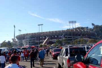 people walk through Candlestick Parking lot to the stadium