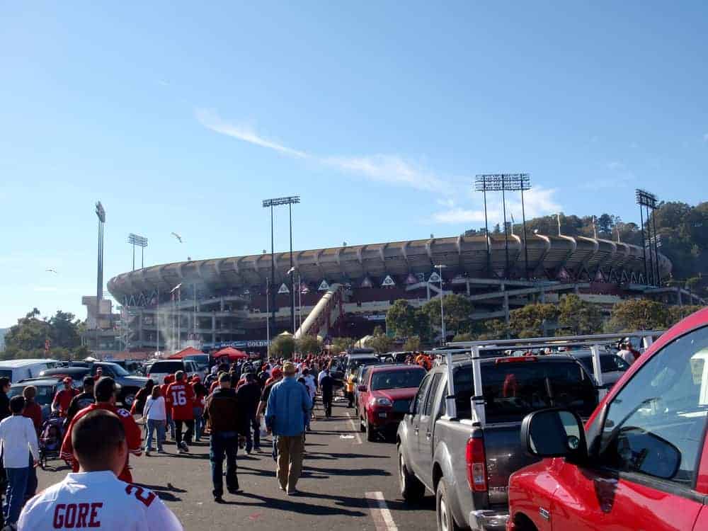 people walk through Candlestick Parking lot to the stadium