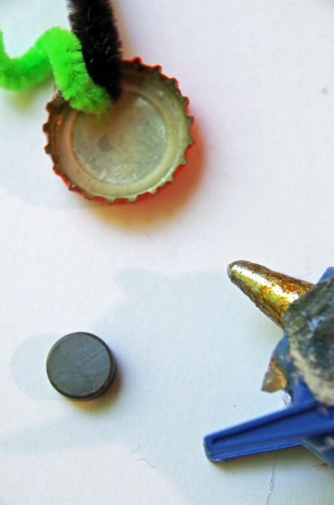 bottle cap, craft supplies, magnet and hot glue gun