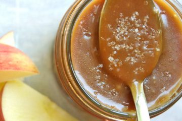 salted caramel sauce in mason jar with spoon and apples