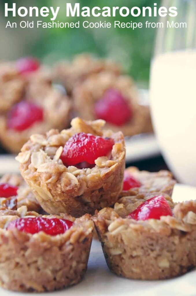 homemade cookies topped with a cherry on a hite plate with text overlay 'Honey Macaroonies: An Old Fashioned Cookie Recipe from Mom'