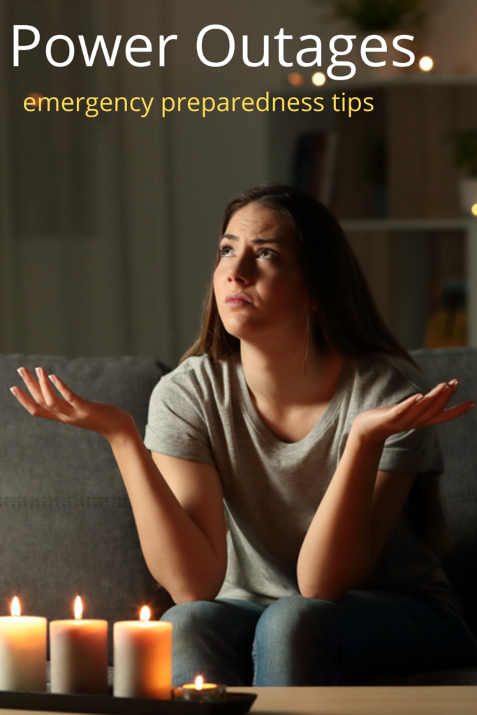 woman sitting on couch with lit candles during power failure at home