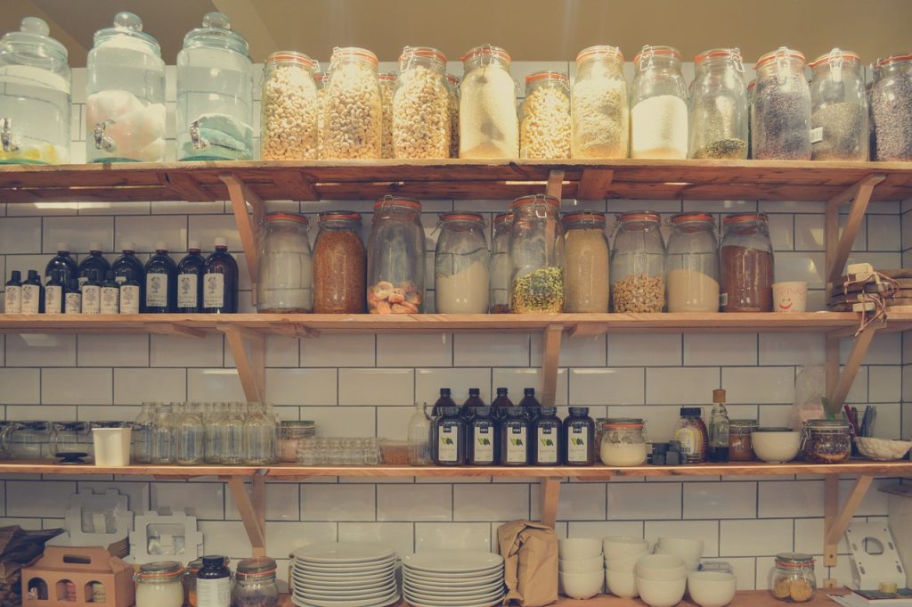 organized shelf full of mason jars with food in them