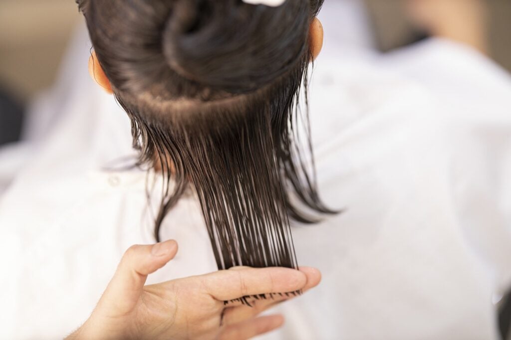 person getting hair cut at hairdresser