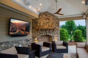 outdoor patio with television, chairs and fire pit