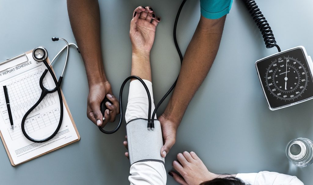 woman getting blood pressure taken at doctor