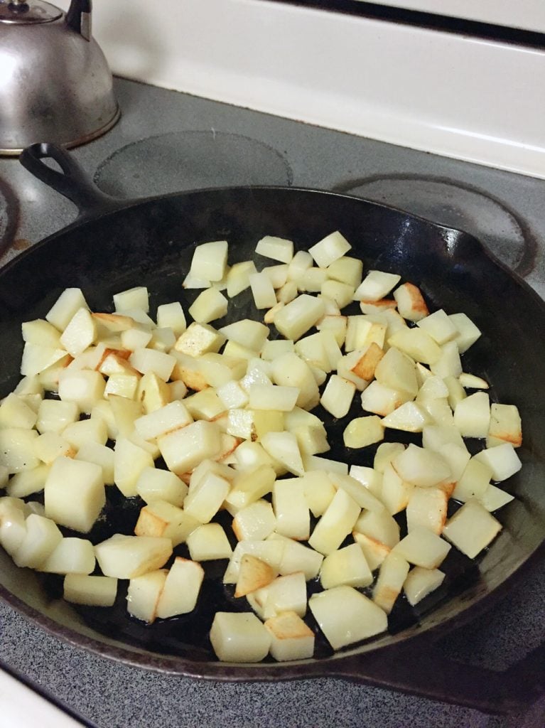 diced potatoes in a cast iron pan