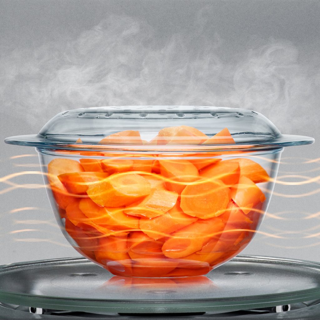 bowl of sliced carrots cooking in the microwave