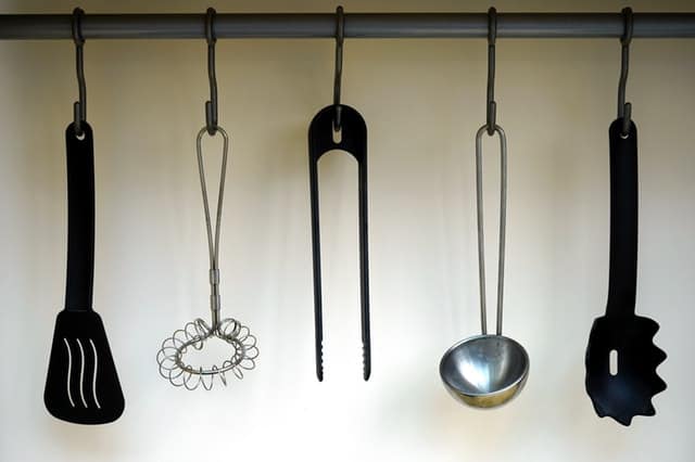 kitchen utensils hanging on wall to create more counter space in kitchen