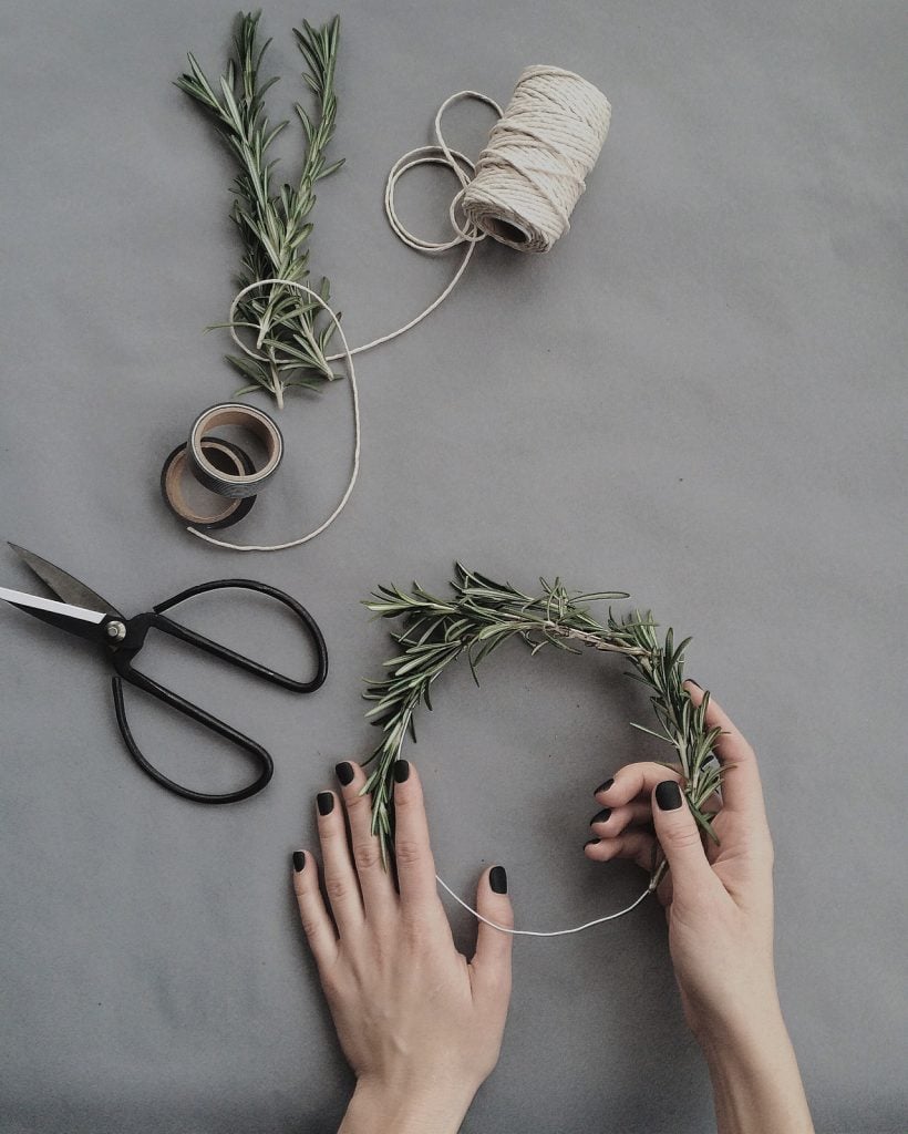 person making natural wreath out of pine branches