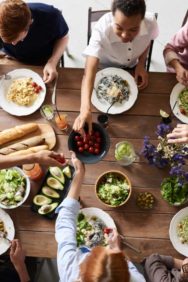 family sitting around kitchen table eating a healthy meal