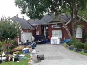workers doing home maintenance on brick home