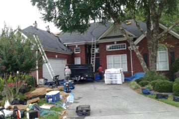 workers doing home maintenance on brick home