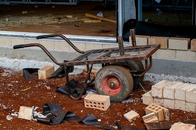 cart and bricks in front of house foundation