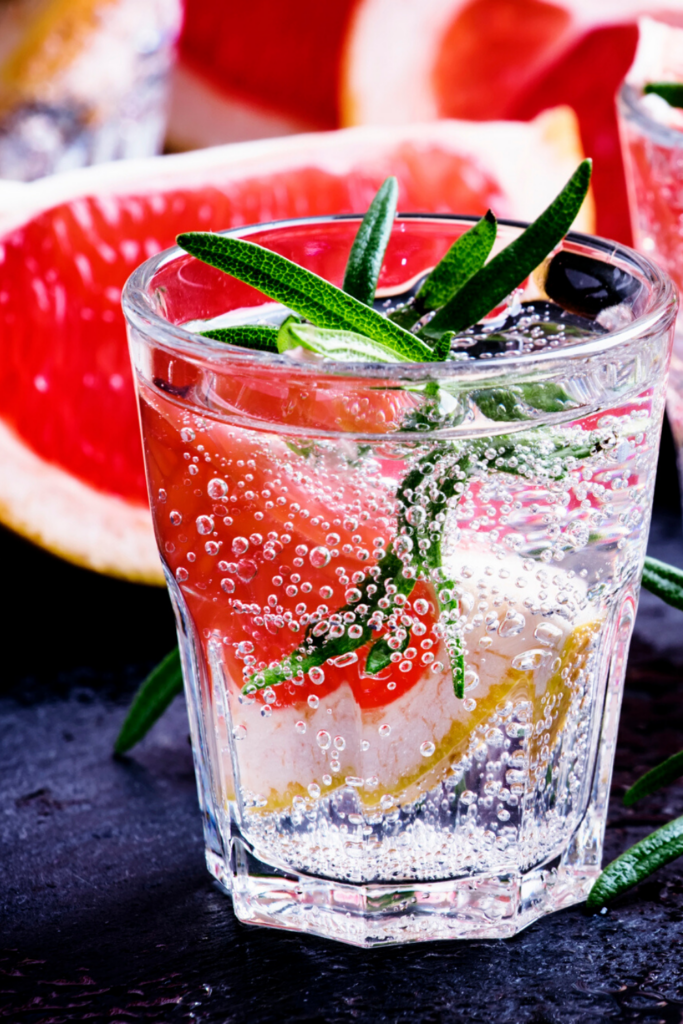 Carbonated citrus and water in glass with herbs