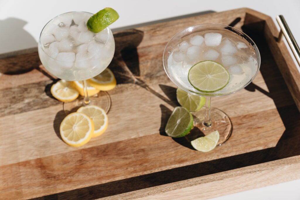 photo of lemons and limes and cocktail glasses on a cutting board