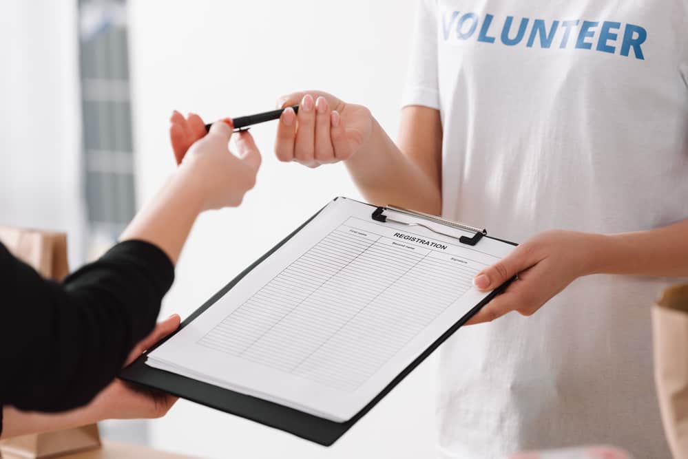 person wearing volunteer shirt and holding clipboard