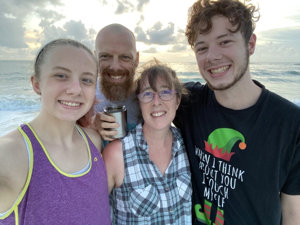 family of parents and teenagers on the beach