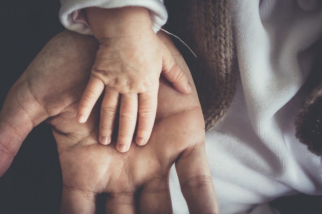 small hand in adult hand indicating family bonding