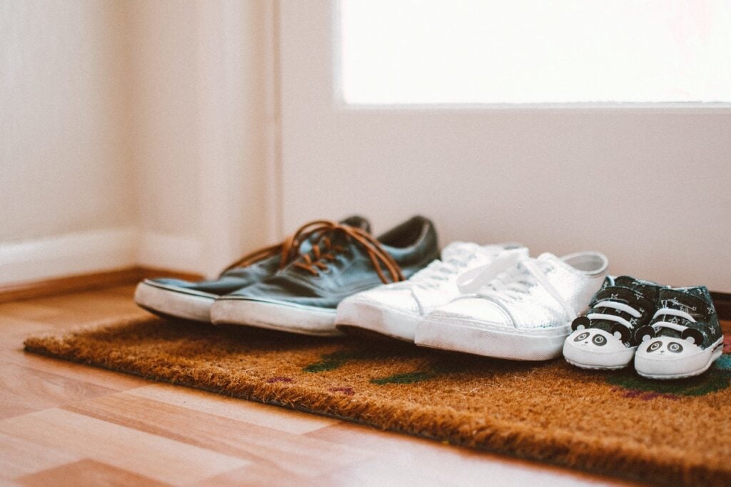 family shoes on a rug in front of a door