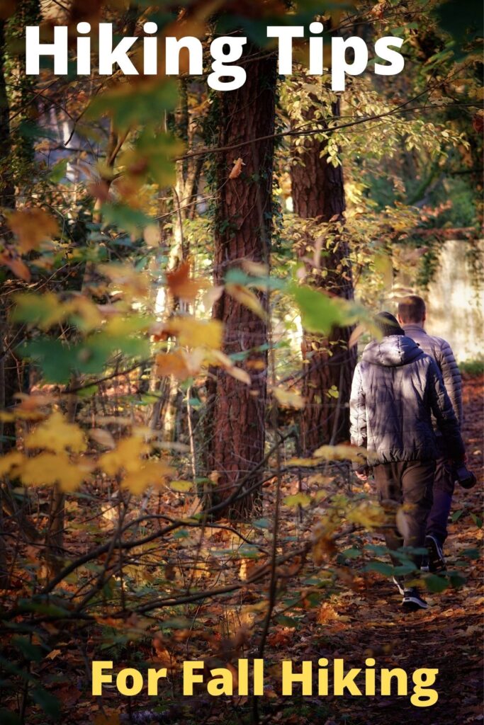 couple hiking in the woods in fall foliage with text overlay 'Hiking Tips for Fall'