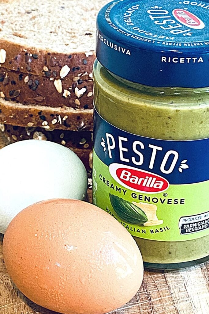 Barilla pesto with eggs and bread on cutting board