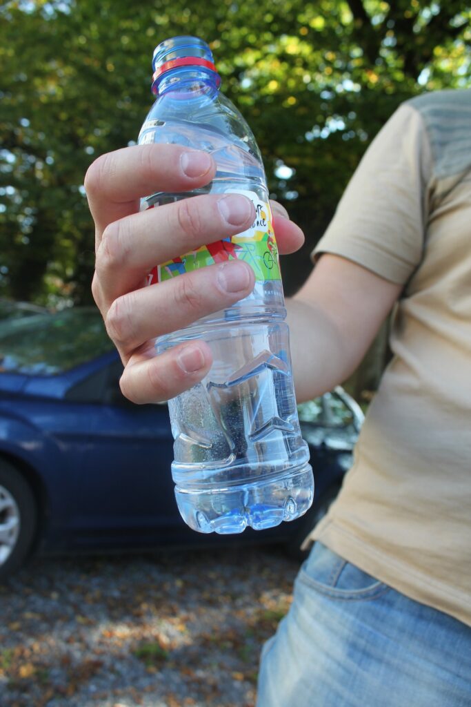 plastic water bottle in a persons hand