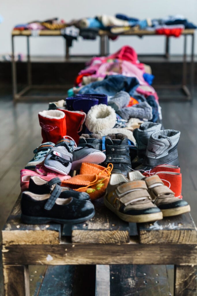 flea market table with piles of old shoes